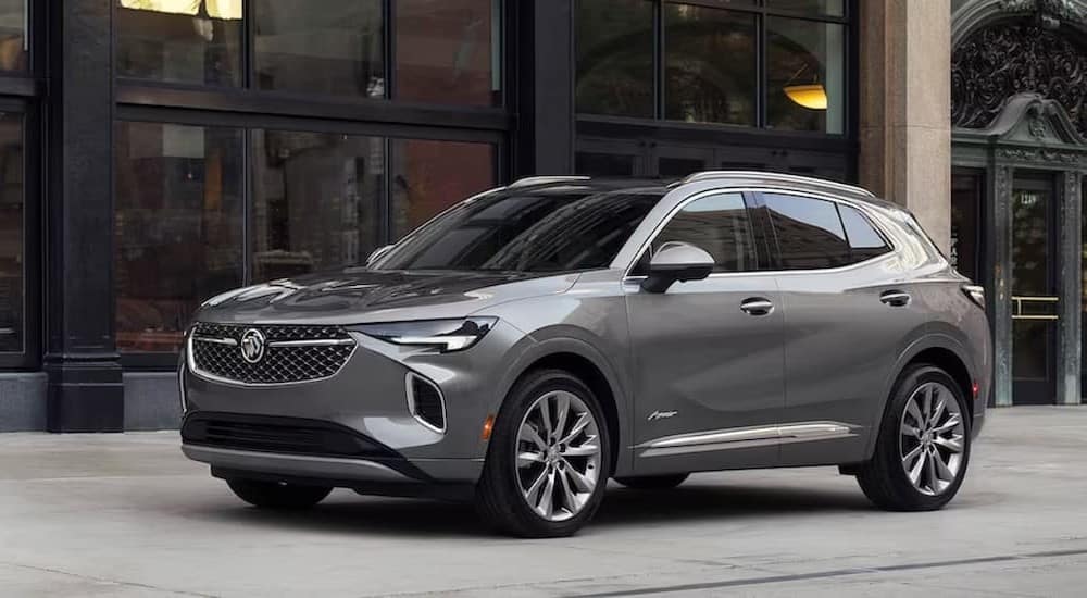 A gray 2023 Buick Envision is shown parked near glass windows.