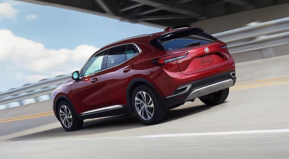 A red 2023 Buick Envision is shown driving on a highway to visit a Buick dealer.
